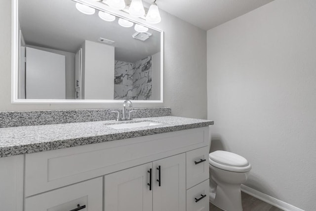 bathroom featuring wood-type flooring, vanity, and toilet