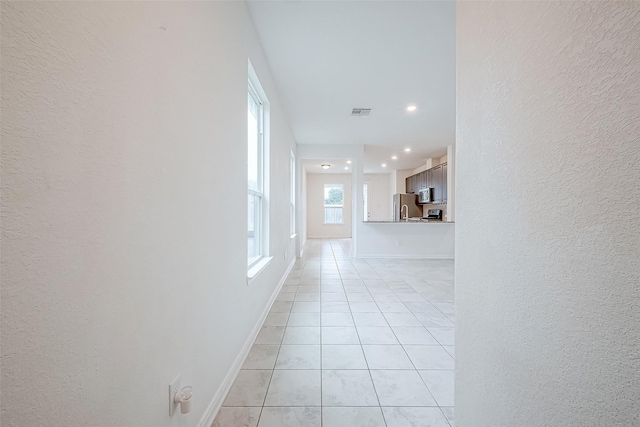 hall with light tile patterned floors