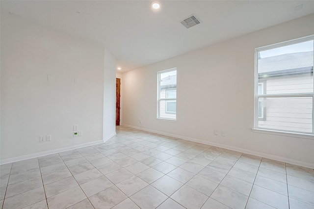 spare room with light tile patterned floors and a wealth of natural light