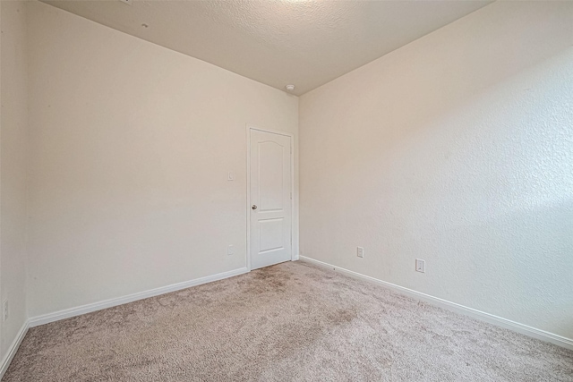 unfurnished room with a textured ceiling, light carpet, and vaulted ceiling