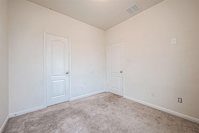 carpeted spare room with a textured ceiling