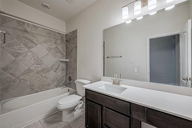 full bathroom with tile patterned floors, vanity, tiled shower / bath combo, and toilet