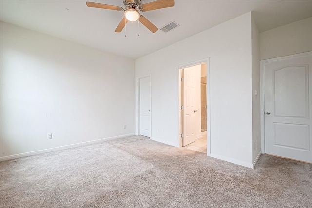 unfurnished bedroom featuring connected bathroom, light colored carpet, and ceiling fan