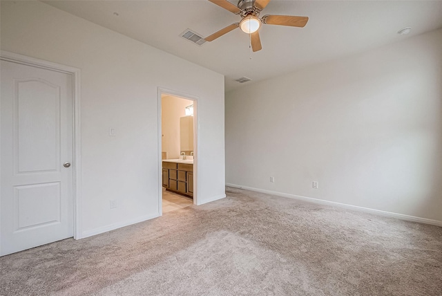 unfurnished bedroom featuring ceiling fan, ensuite bathroom, and light carpet