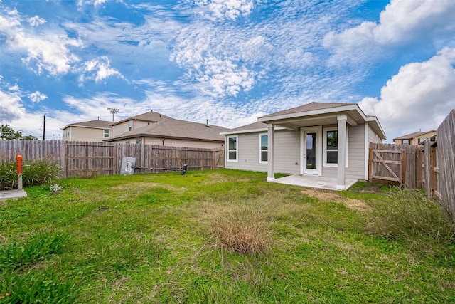 rear view of house with a patio area and a yard