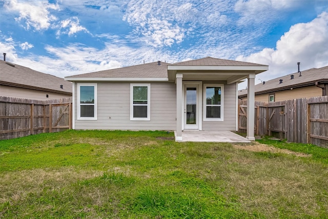 rear view of house featuring a lawn and a patio area