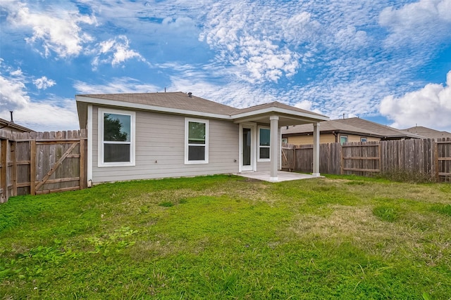 back of property with a patio area and a yard