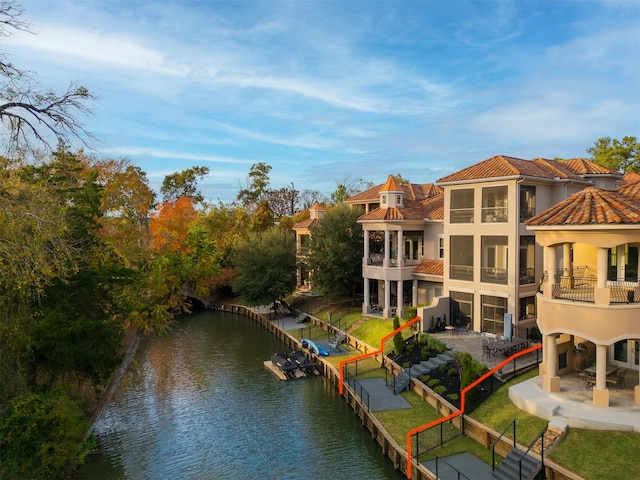 back of house with a patio, a water view, and a balcony