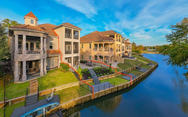 back of property featuring a patio area, a water view, and a balcony