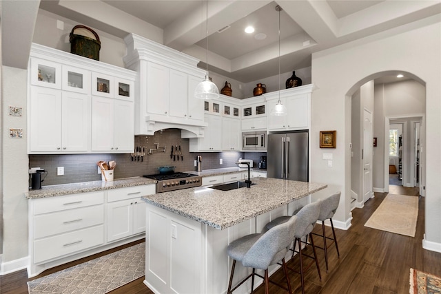 kitchen featuring sink, white cabinetry, stainless steel appliances, and a kitchen island with sink