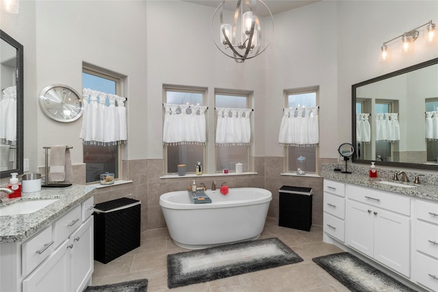 bathroom with tile patterned flooring, vanity, tile walls, and a washtub