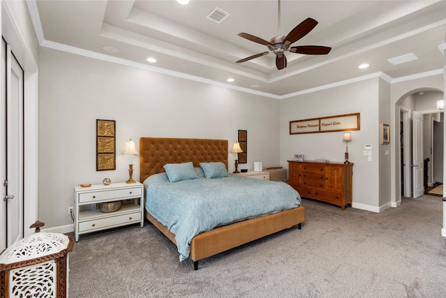 bedroom with carpet flooring, a raised ceiling, ceiling fan, and ornamental molding