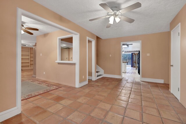 tiled spare room featuring ceiling fan and a textured ceiling