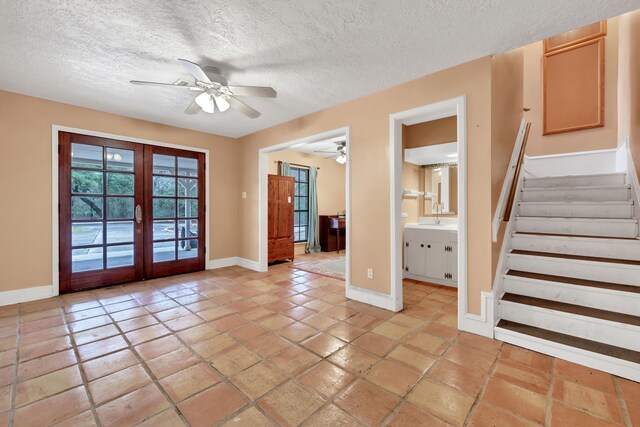 interior space featuring french doors, ceiling fan, and a textured ceiling