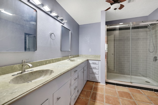 bathroom with vanity, a shower with shower door, and ceiling fan