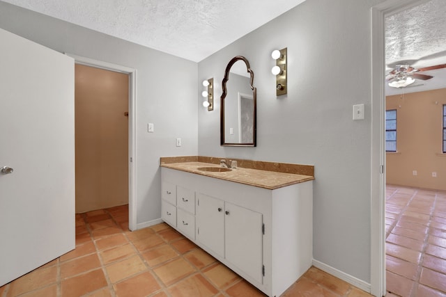 bathroom featuring tile patterned flooring, ceiling fan, vanity, and a textured ceiling