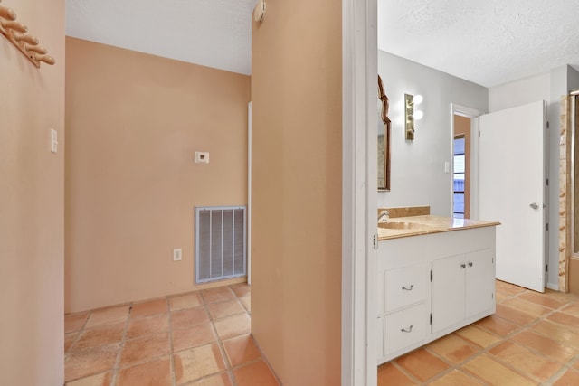 bathroom with vanity, tile patterned floors, and a textured ceiling