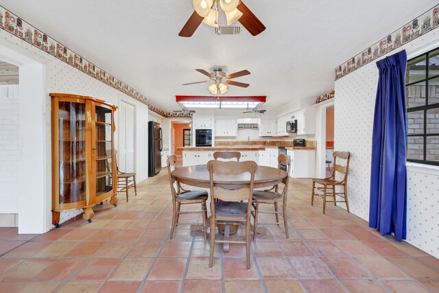 tiled dining room with ceiling fan and sink