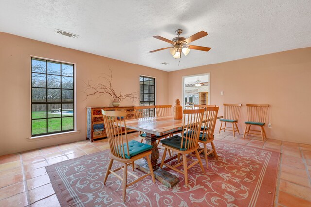 dining area featuring a healthy amount of sunlight, light tile patterned floors, and a textured ceiling