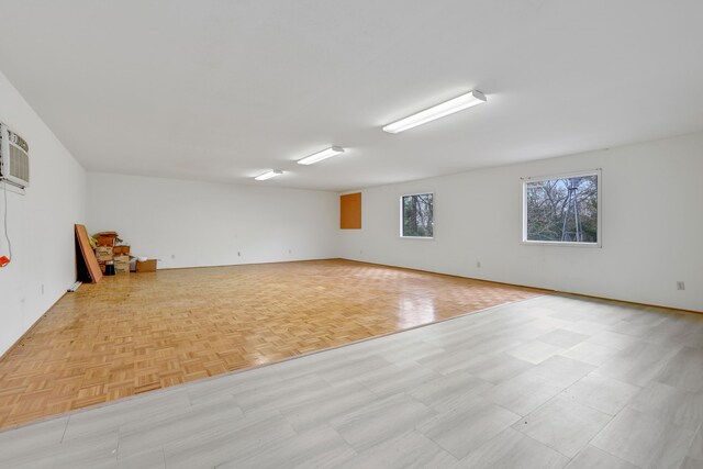 unfurnished room featuring an AC wall unit and light parquet floors