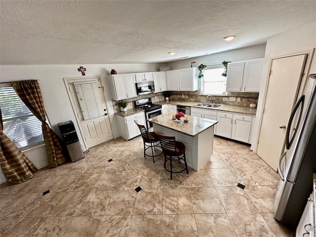 kitchen featuring a center island, backsplash, sink, a breakfast bar area, and stainless steel appliances