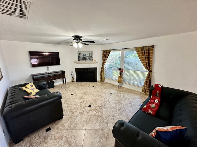 tiled living room featuring ceiling fan and a textured ceiling