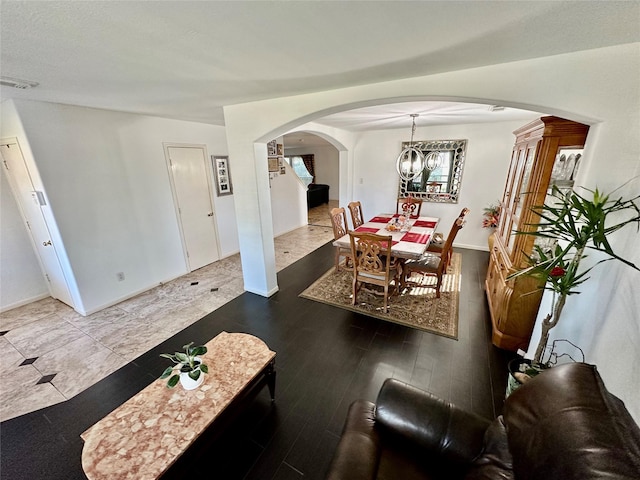 dining area with hardwood / wood-style floors and a notable chandelier