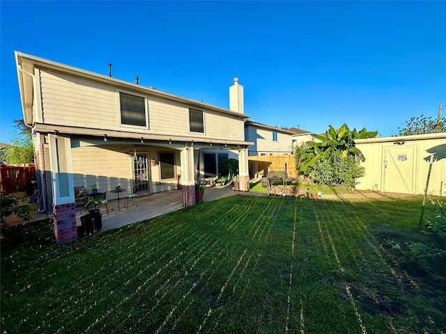 rear view of house featuring a yard and a patio area