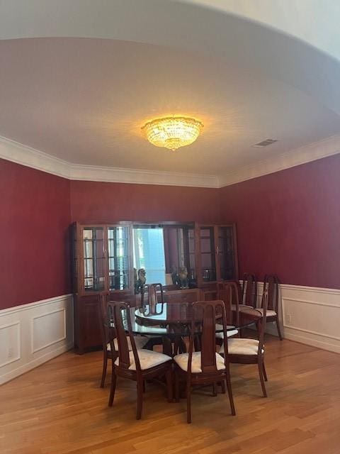 dining area featuring hardwood / wood-style flooring and crown molding