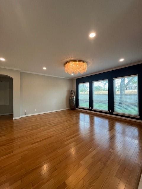 empty room featuring crown molding and hardwood / wood-style flooring