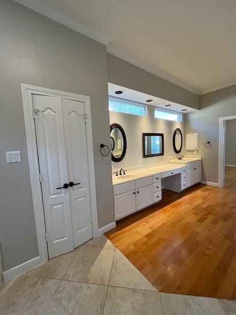 bathroom featuring vanity, wood-type flooring, and ornamental molding