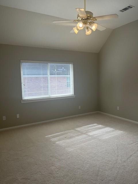 carpeted empty room with vaulted ceiling and ceiling fan