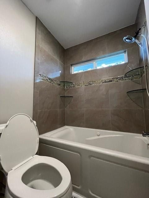 bathroom featuring toilet and tiled shower / bath