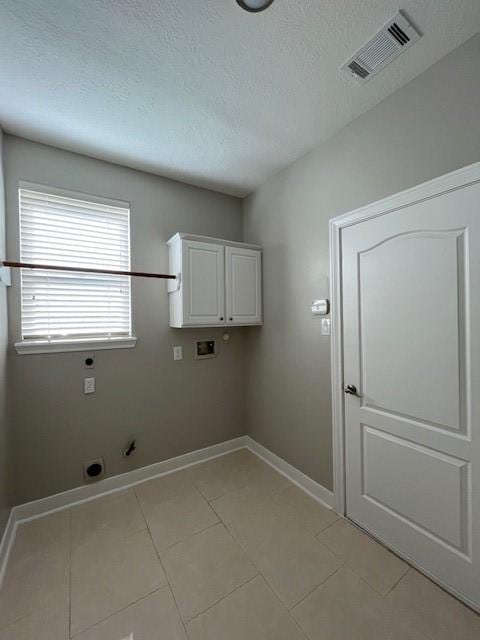 clothes washing area featuring cabinets, washer hookup, light tile patterned floors, and hookup for an electric dryer