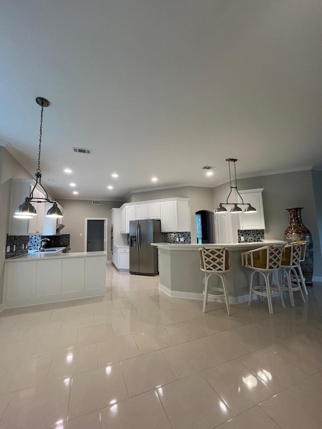 kitchen featuring white cabinetry, stainless steel fridge, light tile patterned flooring, and pendant lighting