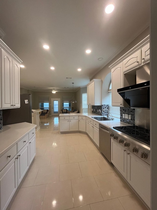 kitchen featuring sink, kitchen peninsula, hanging light fixtures, white cabinetry, and stainless steel appliances