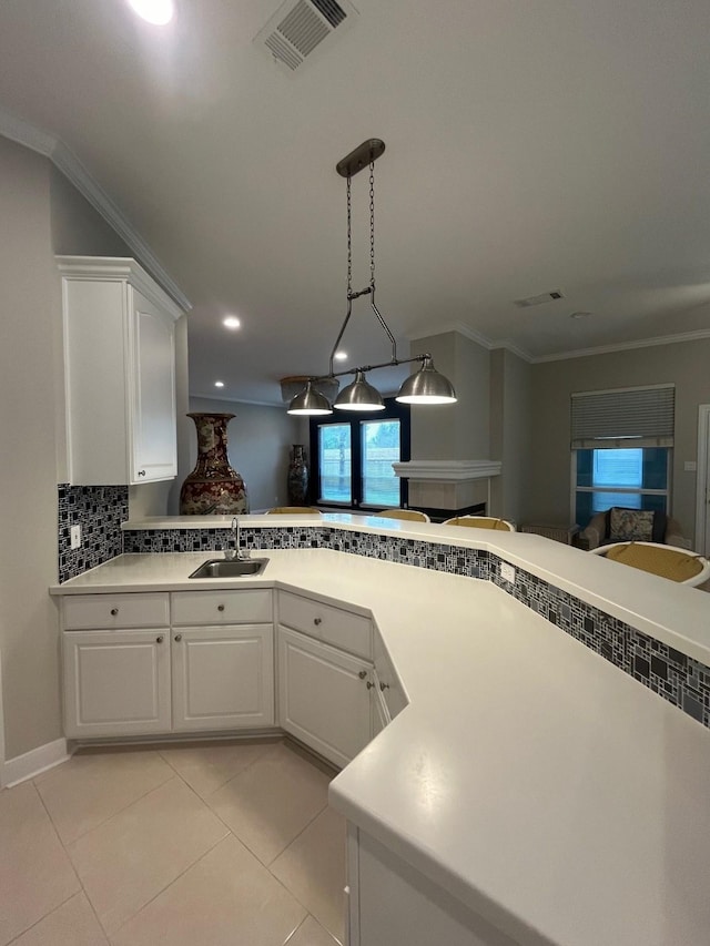 kitchen featuring white cabinets, crown molding, sink, decorative backsplash, and light tile patterned floors