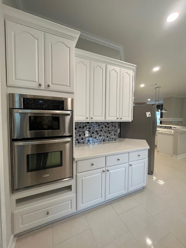 kitchen with crown molding, light tile patterned floors, appliances with stainless steel finishes, tasteful backsplash, and white cabinetry