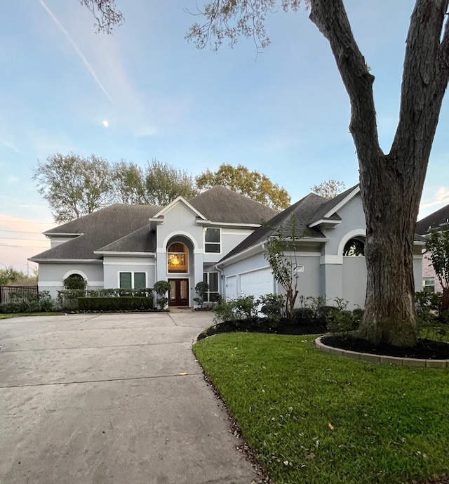 view of front of property featuring a lawn and a garage