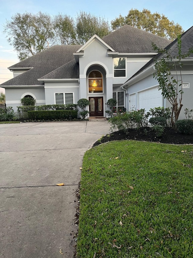 view of front property featuring french doors, a front lawn, and a garage