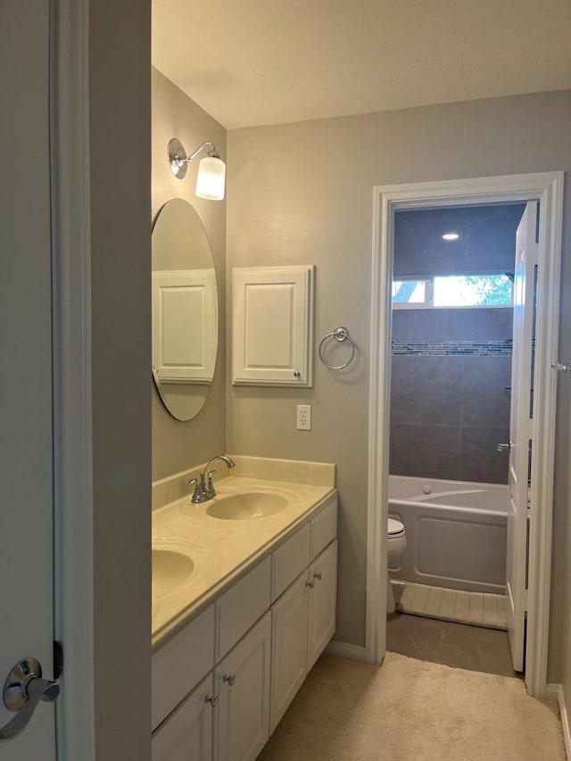 bathroom featuring a washtub, tile patterned floors, vanity, and toilet