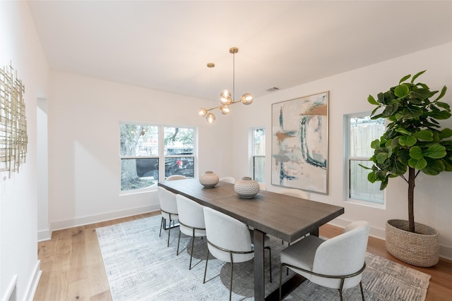 dining area with a chandelier and light wood-type flooring