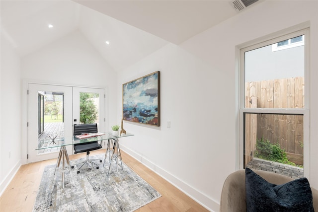 office space with lofted ceiling, french doors, and light hardwood / wood-style flooring