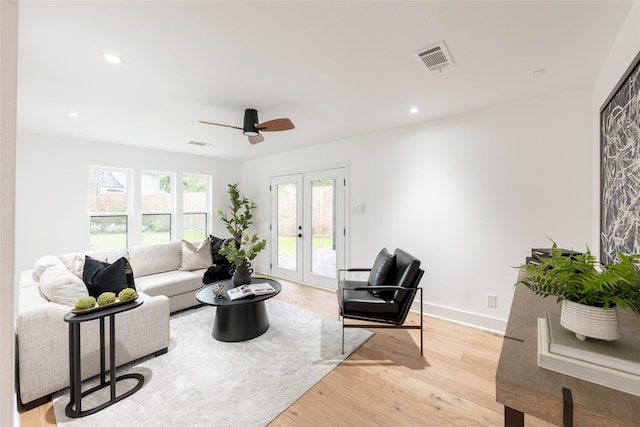 living room featuring ceiling fan, light hardwood / wood-style floors, and french doors