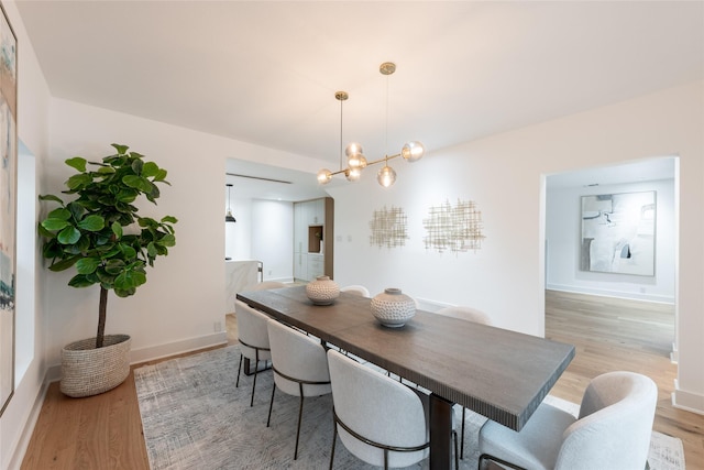 dining area with a chandelier and light wood-type flooring