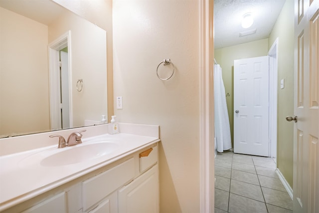 bathroom with a textured ceiling, vanity, and tile patterned floors