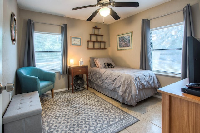 bedroom featuring multiple windows, ceiling fan, and light tile patterned floors