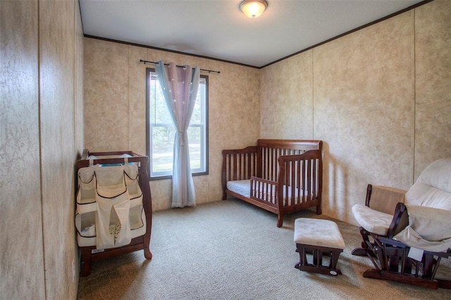 bedroom with crown molding, carpet, and a crib