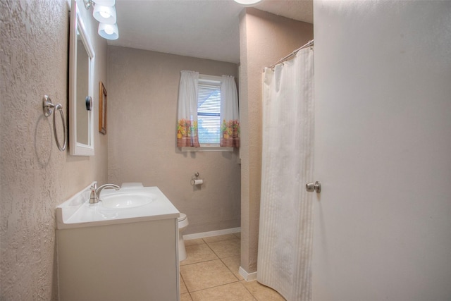 bathroom featuring tile patterned floors, walk in shower, vanity, and toilet