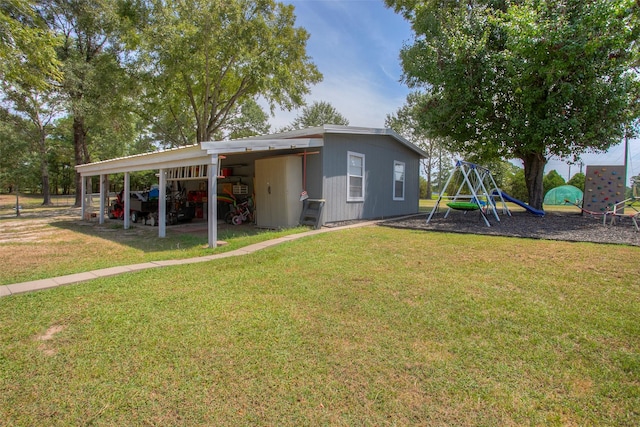 rear view of property with a carport, a playground, and a yard